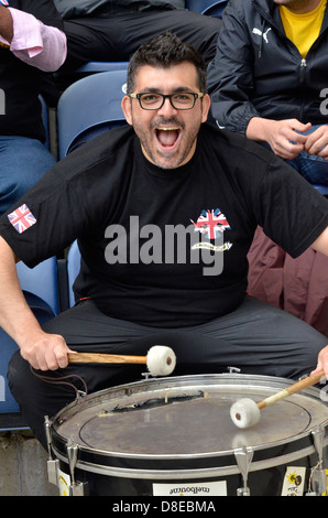 Un fan di Atene dell'AEK bangs un tamburo in un amichevole pre-stagione contro Preston North End al Deepdale Stadium, Lancashire, Regno Unito Foto Stock