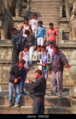 Uomini nepalese celebrare Holi festival, Bhaktapur (Patrimonio Mondiale dell'UNESCO), la valle di Kathmandu, Nepal Foto Stock