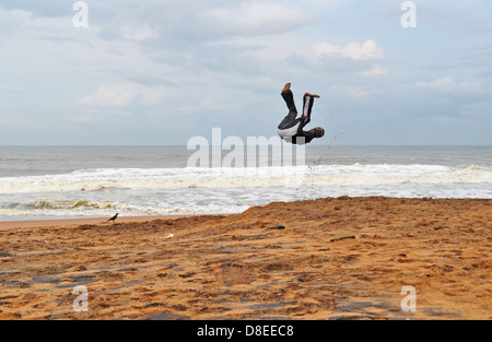 Un acrobat esegue sulla spiaggia Foto Stock