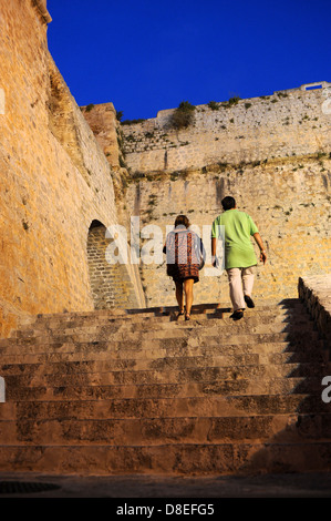 Vacanze a piedi per le scale fino al quartiere del castello in una calda notte d'estate nella città di Ibiza. Foto Stock