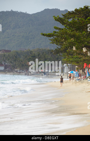 La gente a piedi lungo la spiaggia di Chaweng, Ko Samui, Tailandia Foto Stock