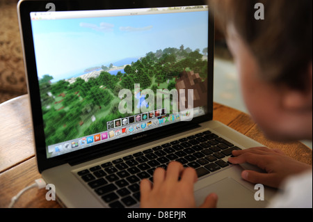 Un 8 anno vecchio ragazzo giocando minecraft sul suo computer Apple IPAD nella sua camera da letto a casa. Foto Stock