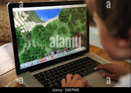 Un 8 anno vecchio ragazzo giocando minecraft sul suo computer Apple IPAD nella sua camera da letto a casa. Foto Stock