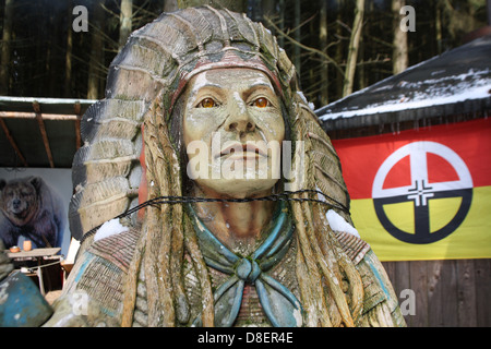 Una scultura in legno di un indiano occidentale che indossa un copricapo in piuma Foto Stock