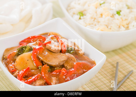 Stile cinese la carne di maiale con peperoni rossi serviti con uovo fritto riso. Foto Stock