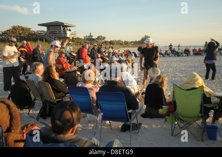 Un gruppo si riunisce su Nokomis, spiaggia della Florida di suonare la batteria come il sole tramonta come parte del cerchio del tamburo. Foto Stock