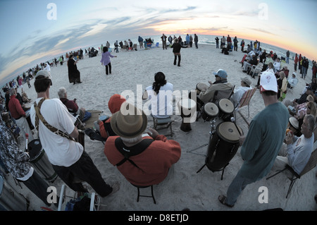 Un gruppo si riunisce su Nokomis, spiaggia della Florida di suonare la batteria come il sole tramonta come parte del cerchio del tamburo. Foto Stock