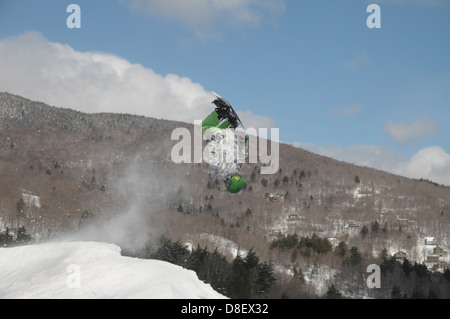 Un estremo snowboarder vola via un salto non è in buona forma come egli è attorno alla Terra su un air bag a Sugarbush Resort in Warren Foto Stock