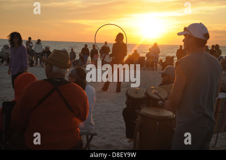 Un gruppo si riunisce su Nokomis, spiaggia della Florida di suonare la batteria come il sole tramonta come parte del cerchio del tamburo. Foto Stock