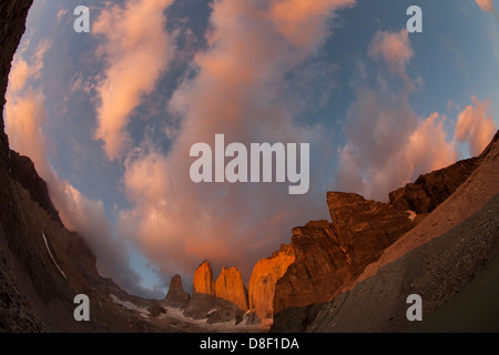 Torres del Paine picchi a sunrise avvolte in nuvole di colore arancione Foto Stock