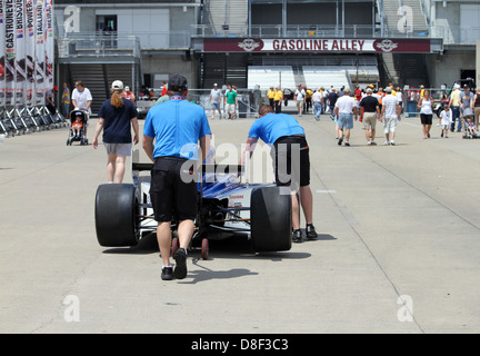 Indy 500 Gara Membri di equipaggio spingendo una vettura da gara al vicolo di benzina Foto Stock