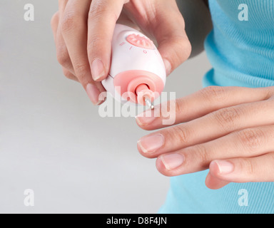 Una donna la sua lucidatura unghie dal polacco chiodo macchina Foto Stock