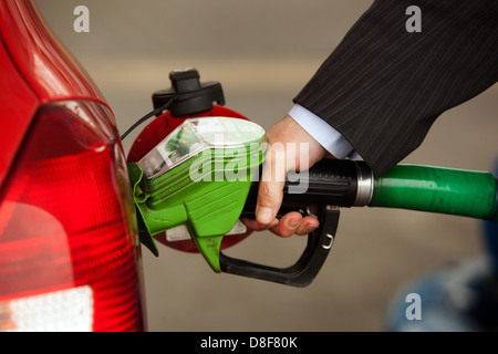 Rifornimento della vettura classica al distributore di benzina, uomo pompando a mano la pistola di benzina e riempie la benzina in una macchina Foto Stock