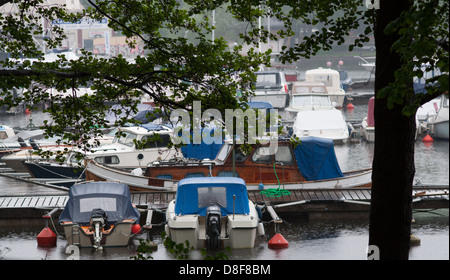 Piccole barche a motore sotto la pioggia su una domenica di maggio in un porto turistico di Stoccolma. Foto Stock