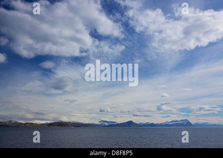 Coste norvegesi vicino Bodo con cime innevate viste dal traghetto alle Lofoten sulla soleggiata giornata estiva Foto Stock