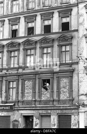 In einem der Grenzhäuser an der Bernauerstraße werden am 1. Oktober 1961 Fenster, die den Blick auf Berlino Ovest freigeben, zugemauert. Kurz nach dem Mauerbau sind Menschen aus den Fenstern der im Ostteil der Stadt gelegenen Häuser auf die zum Westteil gehörende Bernauer Straße geflüchtet. Am frühen Sonntagmorgen des 13. Agosto 1961 wurde unter der Aufsicht von bewaffneten Streitkräften der DDR mit der Errichtung von Straßensperren Stacheldraht aus dem und Bau einer Mauer begonnen, um den Ostteil berlinese Westteil vom abzusperren. Die Mauer sollte den ständig steigenden Flüchtlingsstrom von Ost- Foto Stock