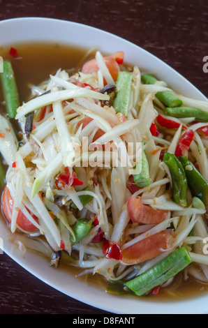 Vista superiore speziata insalata di papaia sul piatto bianco Foto Stock