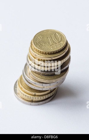 Cambiamento di ricambio. Pila di monete in Euro con moneta superiore a dieci centesimi moneta. Foto Stock