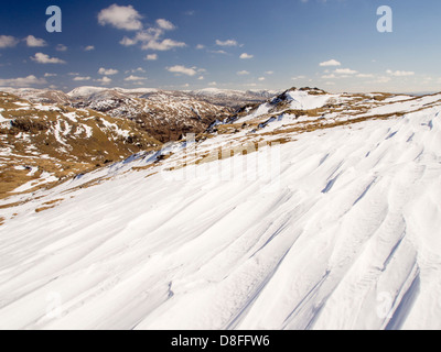 Neve sagomata e ripulita da un forte vento quando cadde, sopra Wrynose Pass nel distretto del lago, Cumbria, Regno Unito. Foto Stock