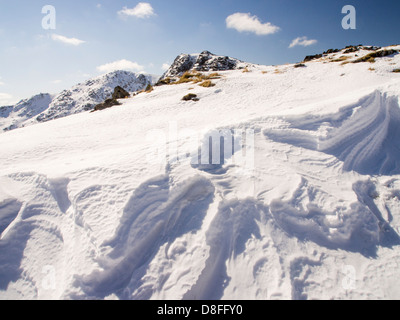 Neve sagomata e ripulita da un forte vento quando cadde, sopra Wrynose Pass nel distretto del lago, Cumbria, Regno Unito. Foto Stock