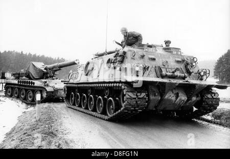 Un serbatoio di blindati dell'esercito degli Stati Uniti sta tirando un mezzo semovente a veicolo di artiglieria durante la manovra della NATO REFORGER I - "Il ritorno delle forze di Germania", il 30 gennaio 1969 vicino a Grafenwöhr, Baviera. Foto Stock