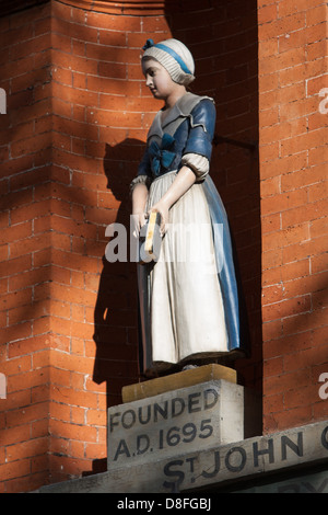 Blue Coat statue di ragazzi e ragazze esterno di St John's Old School, Scandrett Street, Wapping. L'edificio risale al 1756. Foto Stock