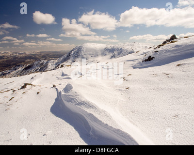 Neve sagomata e ripulita da un forte vento quando cadde, sopra Wrynose Pass nel distretto del lago, Cumbria, Regno Unito. Foto Stock