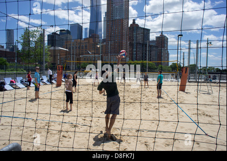 Gli appassionati di sport giocare a beach volley sui campi su Pier 25 in Hudson River Park di New York Foto Stock