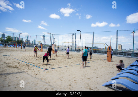 Gli appassionati di sport giocare a beach volley sui campi su Pier 25 in Hudson River Park di New York Foto Stock