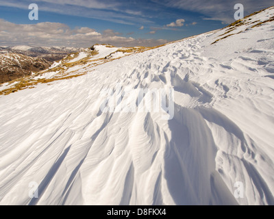 Neve sagomata e ripulita da un forte vento quando cadde, sopra Wrynose Pass nel distretto del lago, Cumbria, Regno Unito. Foto Stock