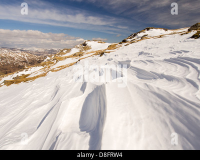 Neve sagomata e ripulita da un forte vento quando cadde, sopra Wrynose Pass nel distretto del lago, Cumbria, Regno Unito. Foto Stock