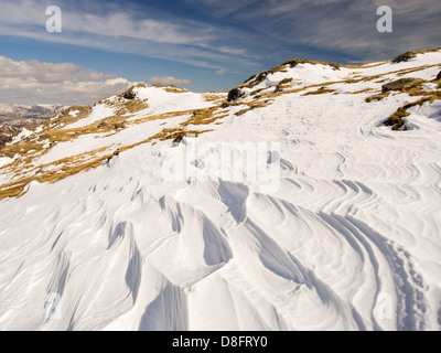 Neve sagomata e ripulita da un forte vento quando cadde, sopra Wrynose Pass nel distretto del lago, Cumbria, Regno Unito. Foto Stock