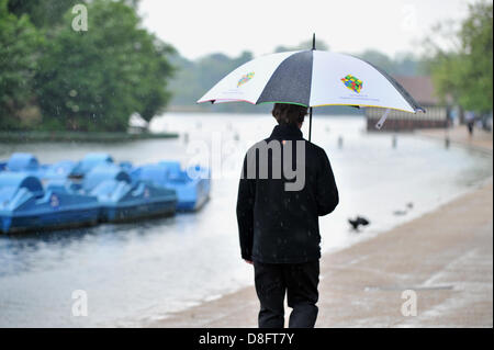 Londra, Regno Unito. Il 28 maggio 2013. Heavy Rain cade a Londra. Un uomo cammina lungo la serpentina in Hyde Park, tenendo un ombrello. Credito: Polly Thomas / Alamy Live News Foto Stock