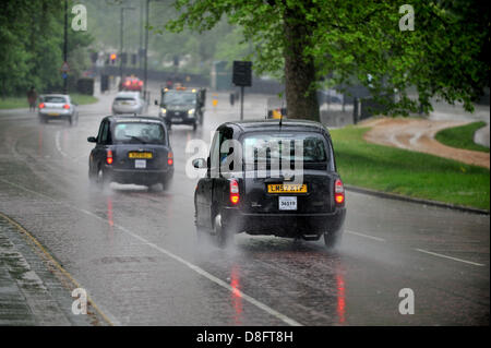 Londra, Regno Unito. Il 28 maggio 2013. Heavy Rain cade a Londra. Black Cabs lascia una scia di spruzzo come essi drive accanto a Hyde Park. Credito: Polly Thomas / Alamy Live News Foto Stock