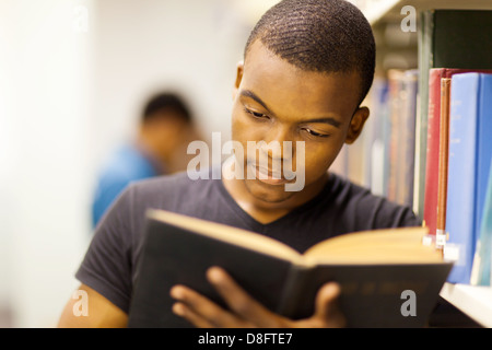 Maschio università africane studente lettura in biblioteca Foto Stock