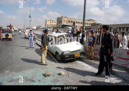 I funzionari di polizia si radunano vicino auto dell avvocato Kausar Saqlian che hanno assassinato da uomini armati non identificati durante la guida lungo con i suoi due figli 12 anni Aun Abbas e quindici anni Muhammad Abbas, a Maripur Road a Karachi il Martedì, 28 maggio 2013. Il Kausar era membro della High Court Bar Association e studioso religiosa, secondo la polizia gli assassini sono stati sulla base settaria. Foto Stock