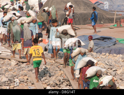 Operai di scarico sulla chiatta Ayeyarwaddy fiume vicino a Mandalay, Myanmar. Foto Stock