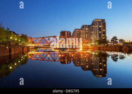 Moderni appartamenti di rosso e un ponte di ferro sul canale di Manchester a Salford Quays, Greater Manchester, Inghilterra Foto Stock