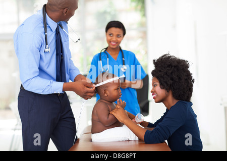 Maschio medico africano facendo checkup sul baby boy in office Foto Stock