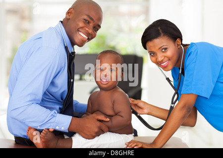 Bella donna africana infermiera esaminando little boy con connettore maschio di tipo medico Foto Stock