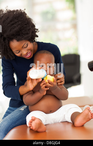 Madre africana alimentando il suo figlio in ufficio medici Foto Stock