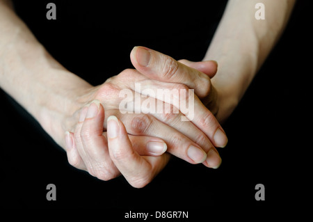 Differenti posizioni di senior donna di mani su sfondo nero Foto Stock