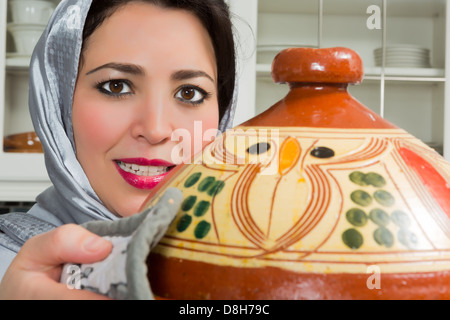 Immigrati marocchini donna in Europa presentando il suo Piatto per tajine durante il Ramadan nella sua cucina moderna Foto Stock