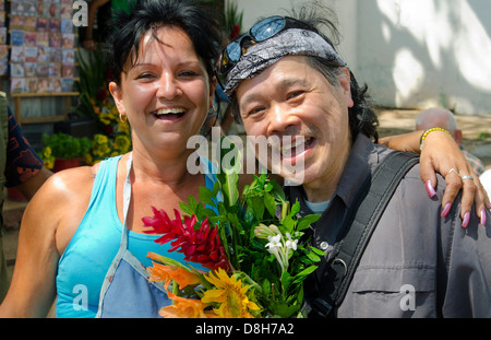 L'Avana Cuba donna vendita di fiori nel mercato turistico cinese e sorridente Foto Stock