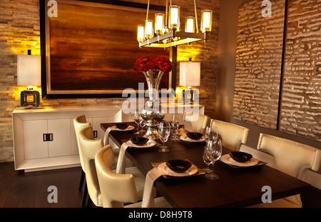 Casa di lusso del valore di diversi milioni di dollari sala da pranzo con piatti e muro di pietra Foto Stock