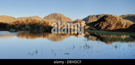 Grande timpano riflette in Innominate Tarn su Haystacks su un cielo blu chiaro serata nel Lake District inglese Foto Stock