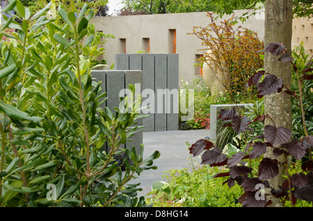 Vista delle mura, posti a sedere e di una scultura in BrandAlley fresco giardino ad RHS Chelsea Flower Show 2013 Foto Stock