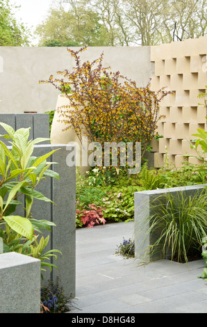 Vista delle mura, posti a sedere e di una scultura in BrandAlley fresco giardino ad RHS Chelsea Flower Show 2013 Foto Stock