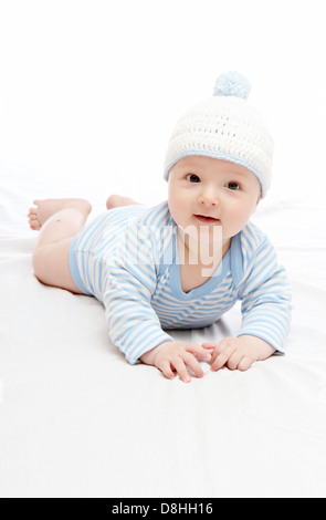 Magnifico bambino in blu hat sul letto Foto Stock