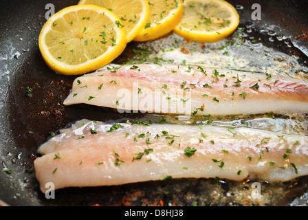 Cucinare il pesce bianco con le fette di limone Foto Stock